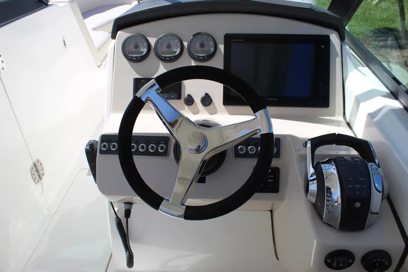 Slide: The Image of 2018 Boston Whaler 270 Vantage helm with steering wheel, gauges, and controls. - 45