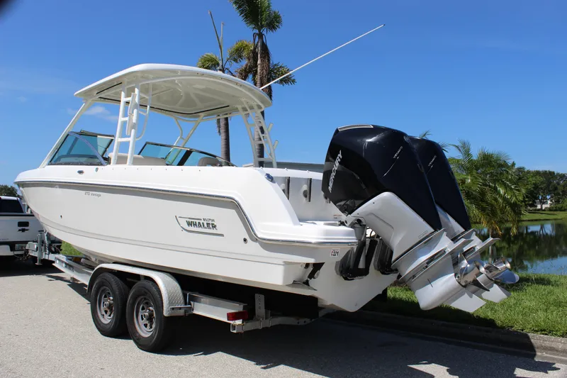 Slide: The Image of 2018 Boston Whaler 270 Vantage boat on trailer, dual outboard engines, sunny day. - 8