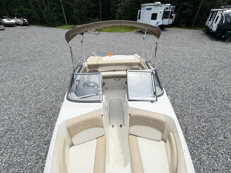 Slide: The Image of 2016 Stingray 188 LX boat with beige interior and canopy, parked on gravel. - 20