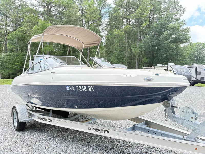 Slide: The Image of 2016 Stingray 188 LX boat on trailer, parked outdoors with trees in background. - 6