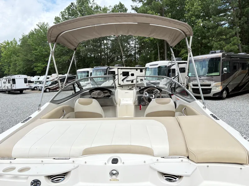 Slide: The Image of 2016 Stingray 188 LX boat with canopy, parked near RVs in a wooded area. - 8