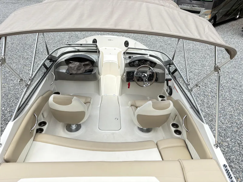 Slide: The Image of 2016 Stingray 188 LX boat interior with beige seating and steering wheel under canopy. - 9
