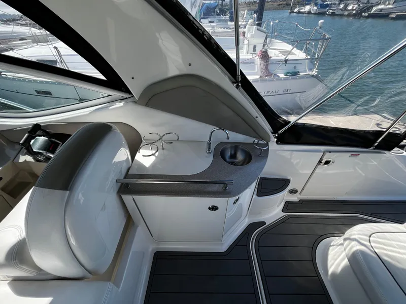 Slide: The Image of 2006 Sea Ray 290 Sundancer interior with sink and seating, docked at marina. - 10