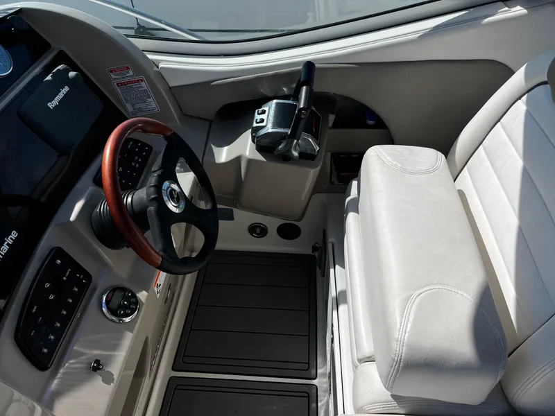 Slide: The Image of 2006 Sea Ray 290 Sundancer helm with steering wheel and control panel. - 11