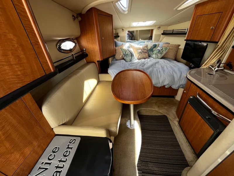 Slide: The Image of Interior of 2006 Sea Ray 290 Sundancer with cozy seating, bed, and kitchenette. - 13