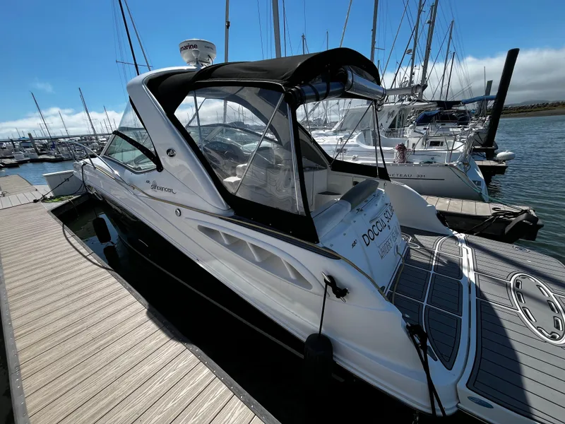 Slide: The Image of 2006 Sea Ray 290 Sundancer docked at marina, featuring sleek design and spacious deck. - 2