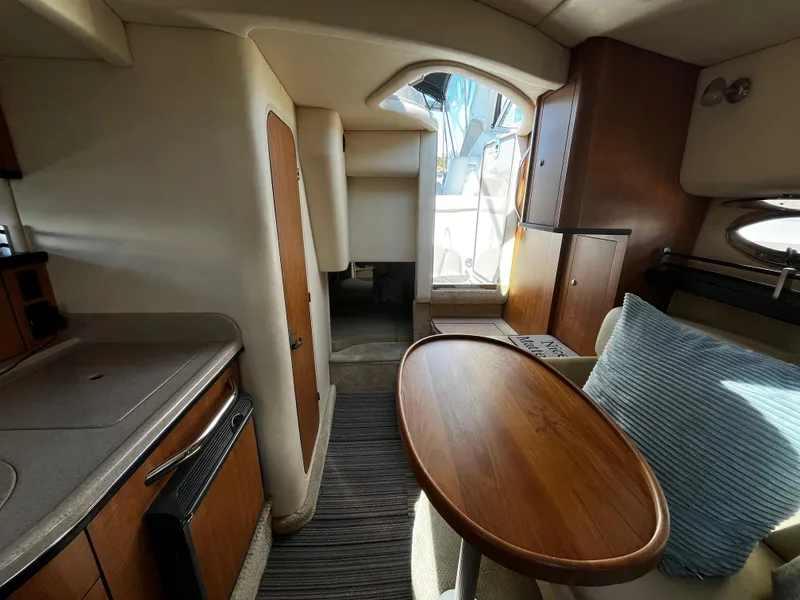 Slide: The Image of Interior of 2006 Sea Ray 290 Sundancer, featuring a cozy cabin with wood accents. - 20