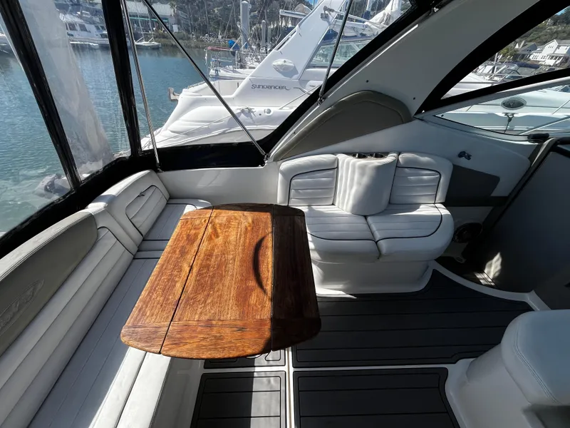 Slide: The Image of 2006 Sea Ray 290 Sundancer interior with wooden table and white seating. - 29