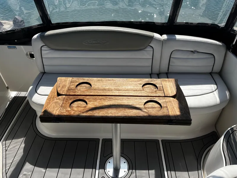 Slide: The Image of 2006 Sea Ray 290 Sundancer interior with wooden table and cushioned seating. - 30