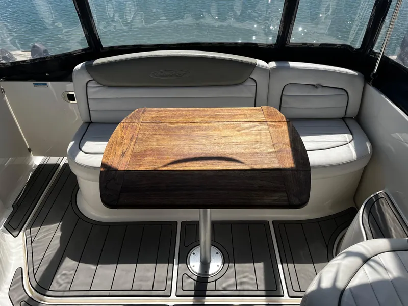 Slide: The Image of 2006 Sea Ray 290 Sundancer interior with wooden table and cushioned seating. - 31