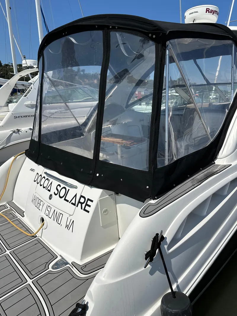 Slide: The Image of 2006 Sea Ray 290 Sundancer docked, featuring a covered cockpit and visible boat name. - 33