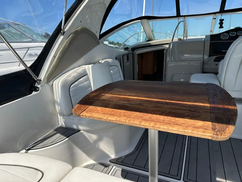 Slide: The Image of 2006 Sea Ray 290 Sundancer interior with wooden table and white seating. - 34