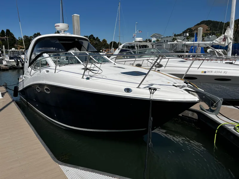 Slide: The Image of 2006 Sea Ray 290 Sundancer docked at a marina under clear blue skies. - 5