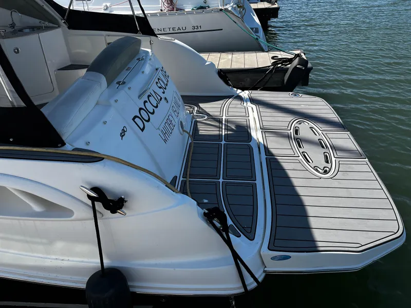 Slide: The Image of 2006 Sea Ray 290 Sundancer docked, featuring a spacious swim platform and sleek design. - 7