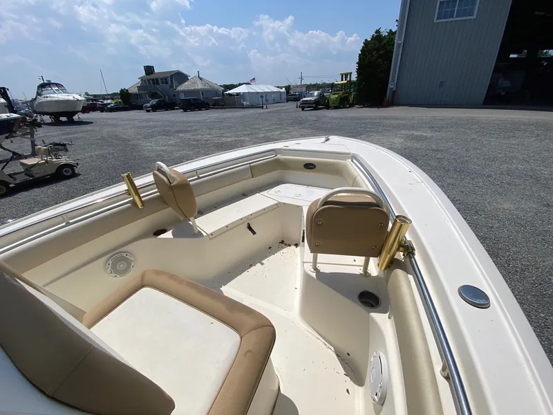 Slide: The Image of 2012 Scout 225 XSF boat interior with seating, docked outdoors under a clear sky. - 10