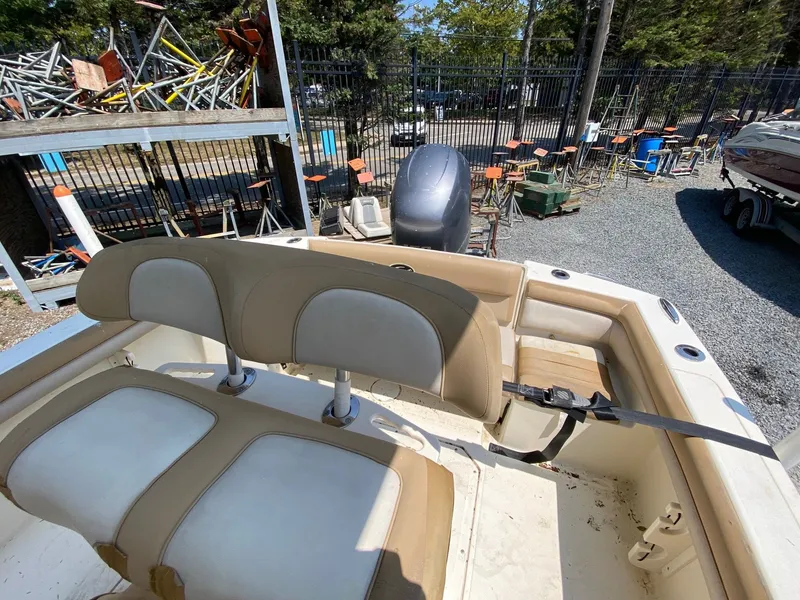 Slide: The Image of 2012 Scout 225 XSF boat interior with beige seating and outboard motor. - 11