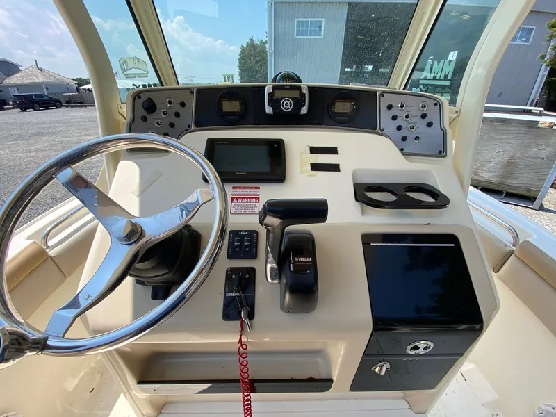 Slide: The Image of 2012 Scout 225 XSF boat dashboard with steering wheel and controls. - 5