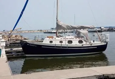 The Image of 1987 Pacific Seacraft Dana 24 sailboat docked at marina, blue hull, covered sails. - 0