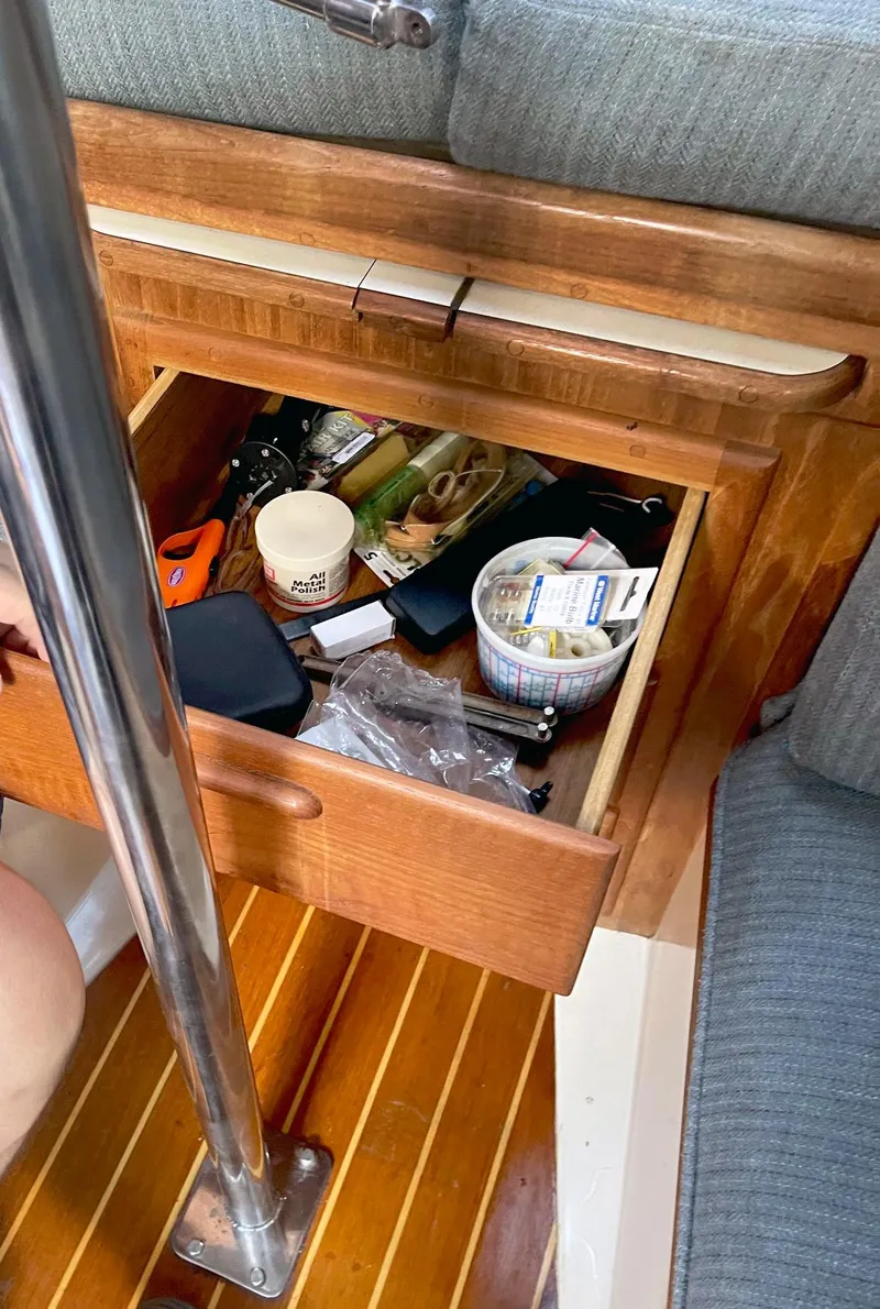 Slide: The Image of Open drawer on 1987 Pacific Seacraft Dana 24 sailboat, containing various items and tools. - 14