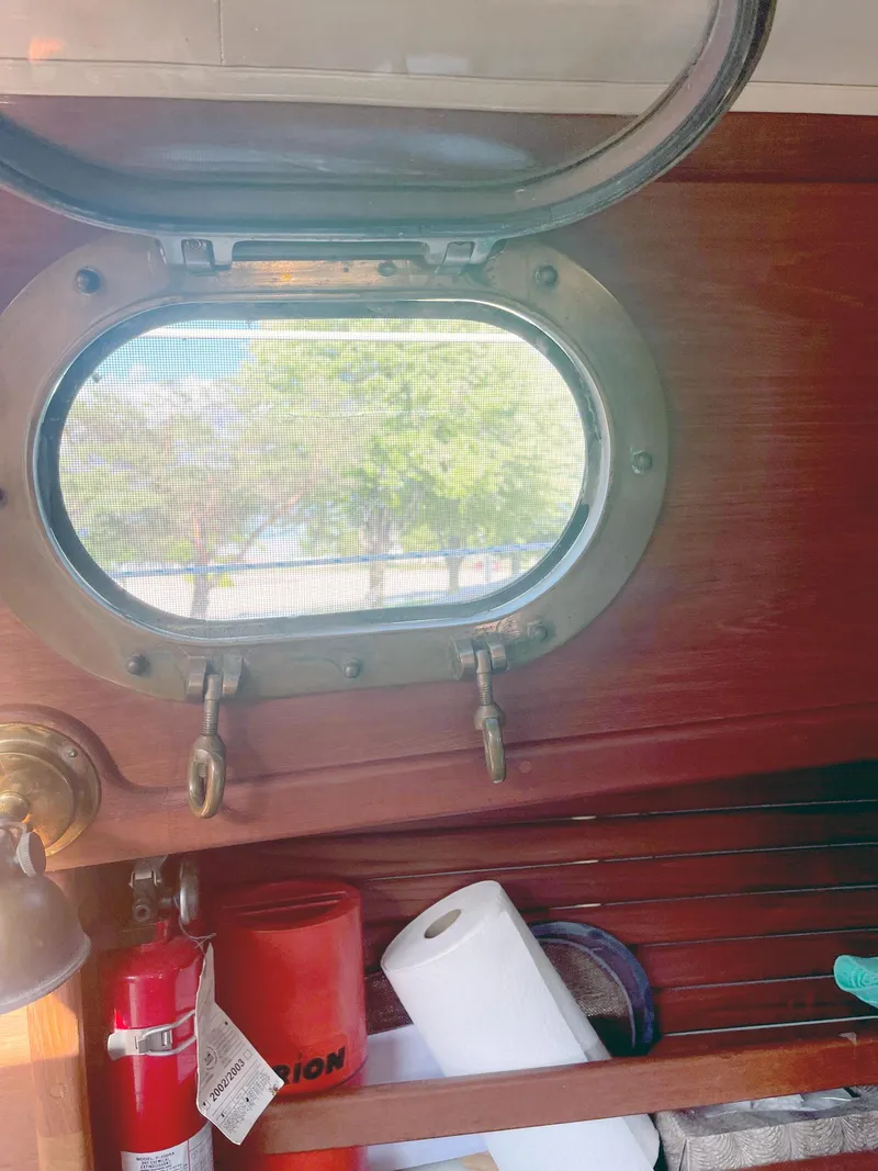 Slide: The Image of Interior of 1987 Pacific Seacraft Dana 24 with open porthole and safety equipment. - 15
