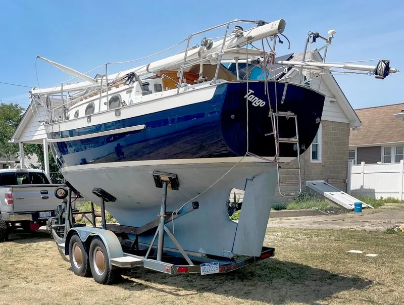 Slide: The Image of 1987 Pacific Seacraft Dana 24 sailboat on trailer, parked in residential area. - 3