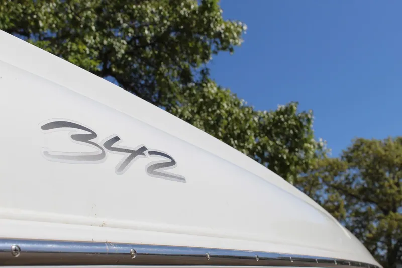 Slide: The Image of 2002 Baja 342 boat with logo, set against a clear blue sky and trees. - 13