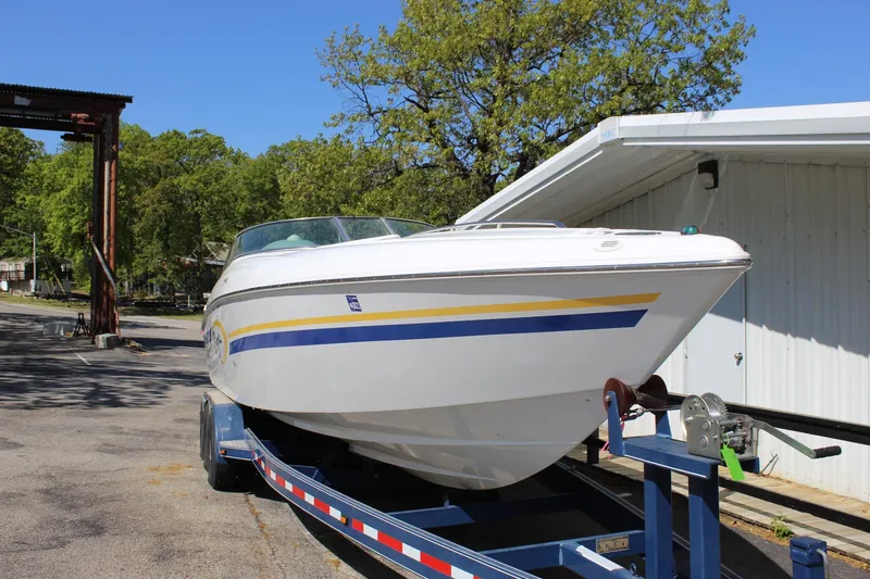 Slide: The Image of 2002 Baja 342 boat on trailer, parked outdoors near a building. - 14