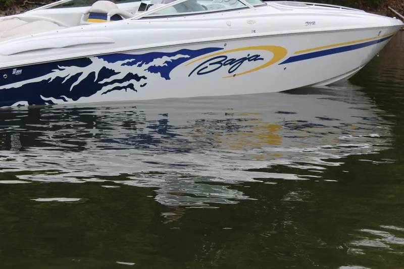 Slide: The Image of 2002 Baja 342 speedboat with blue and yellow graphics on water. - 3