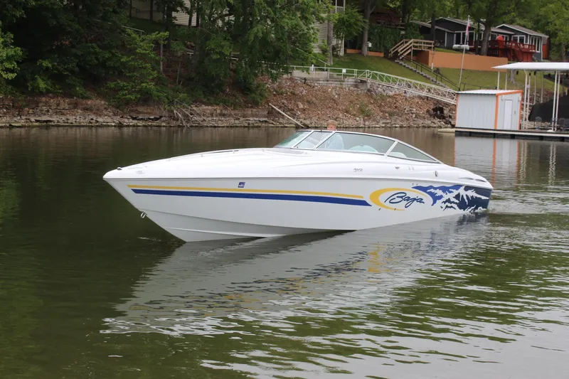 Slide: The Image of 2002 Baja 342 speedboat cruising on a calm lake near a wooded shoreline. - 4