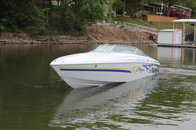 Slide: The Image of 2002 Baja 342 speedboat cruising on a calm lake near a wooded shoreline. - 5
