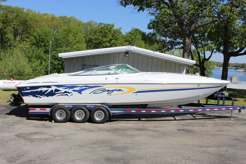 Slide: The Image of 2002 Baja 342 speedboat on trailer, parked outdoors near a lake. - 7