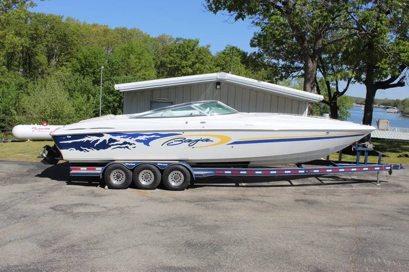 Slide: The Image of 2002 Baja 342 speedboat on trailer, parked outdoors near trees and water. - 9