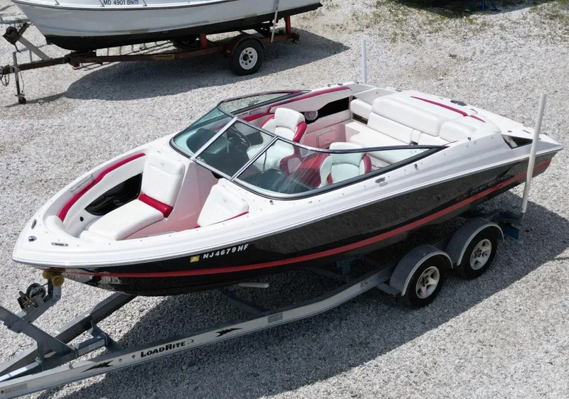 Slide: The Image of 2009 Regal 2200 Bowrider boat on trailer, featuring sleek design and spacious seating. - 11