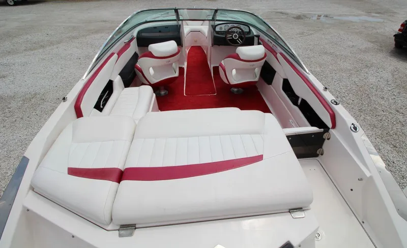 Slide: The Image of 2009 Regal 2200 Bowrider boat interior with white and red seating, steering wheel, and dashboard. - 12