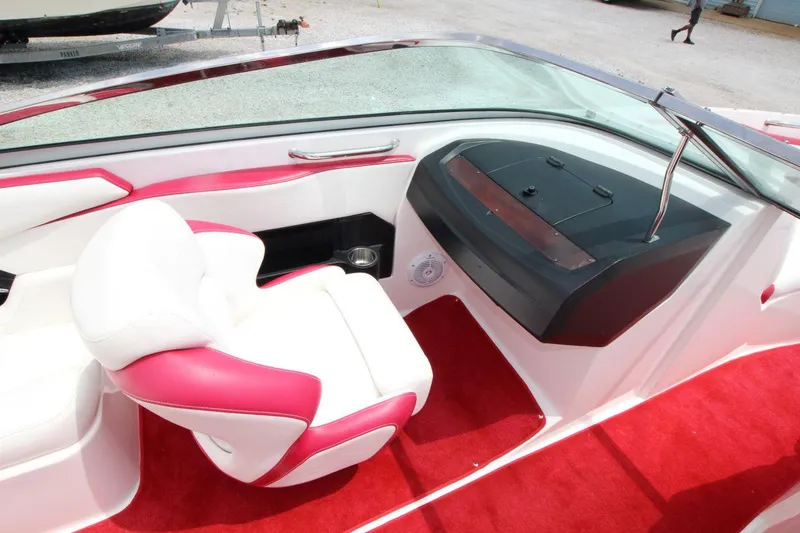 Slide: The Image of 2009 Regal 2200 Bowrider interior with red and white seating, dashboard, and carpet. - 16