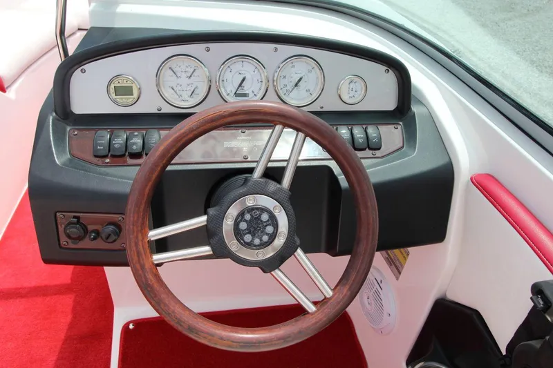 Slide: The Image of 2009 Regal 2200 Bowrider dashboard with wooden steering wheel and gauges. - 17