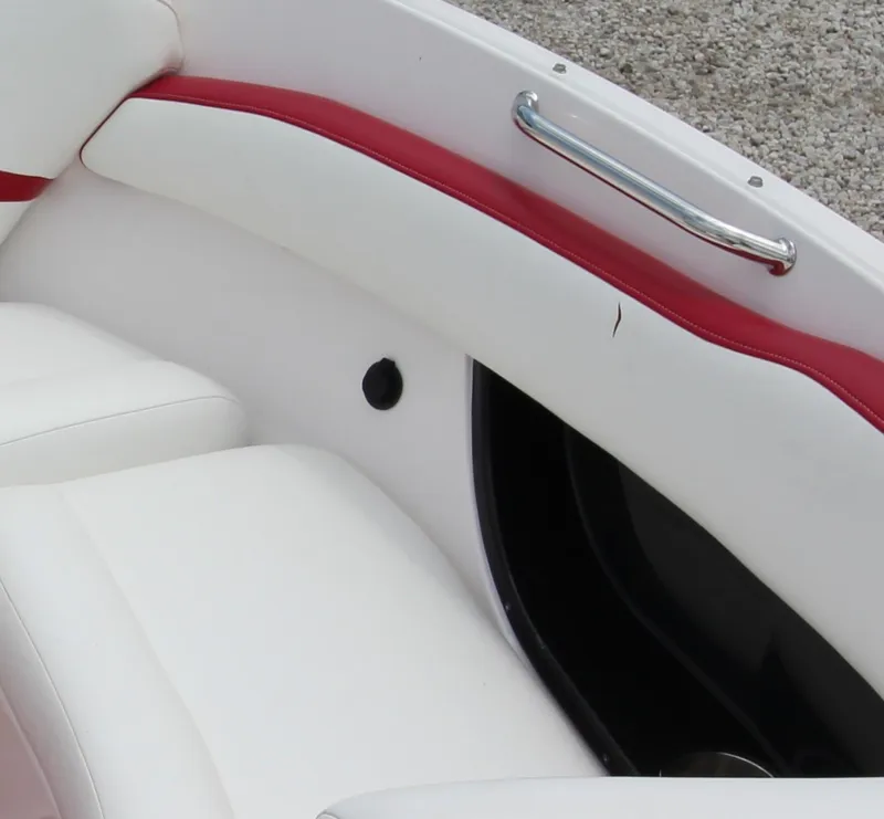 Slide: The Image of 2009 Regal 2200 Bowrider interior with white and red seating, chrome handle, and textured flooring. - 21
