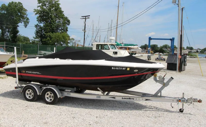 Slide: The Image of 2009 Regal 2200 Bowrider boat on trailer, covered, parked in marina. - 3