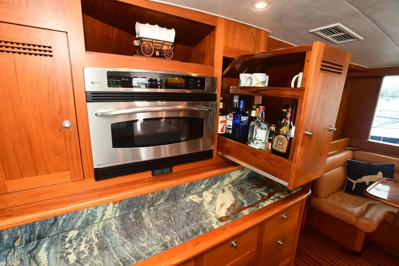 Slide: The Image of 1988 Bertram 54 Convertible yacht kitchen with wood cabinetry, marble countertop, and built-in oven. - 14