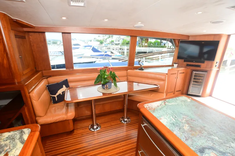 Slide: The Image of Interior of 1988 Bertram 54 Convertible yacht with leather seating, wooden table, and large windows. - 16
