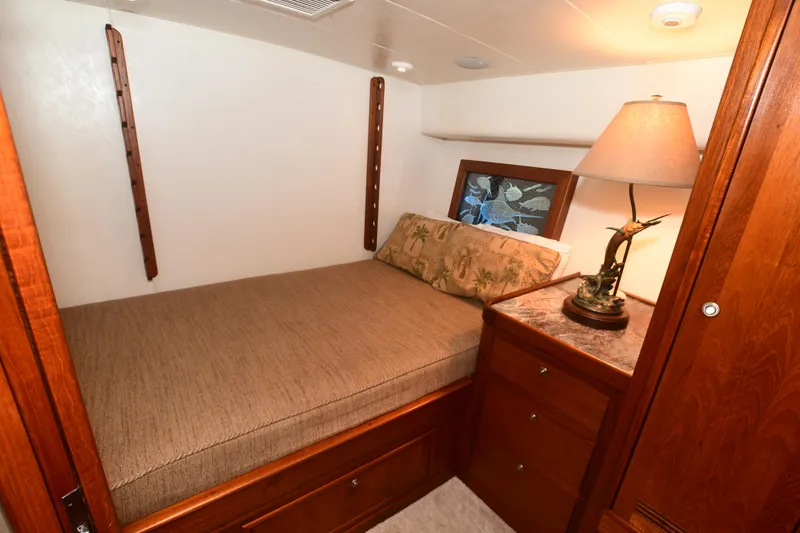 Slide: The Image of Cozy cabin interior of 1988 Bertram 54 Convertible yacht with bed and lamp. - 19