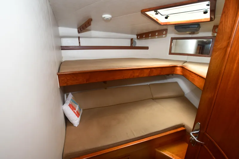 Slide: The Image of 1988 Bertram 54 Convertible cabin with wooden bunk beds and a skylight. - 20