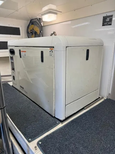 Slide: The Image of Generator unit inside a 1988 Bertram 54 Convertible yacht, featuring a clean, white enclosure. - 33