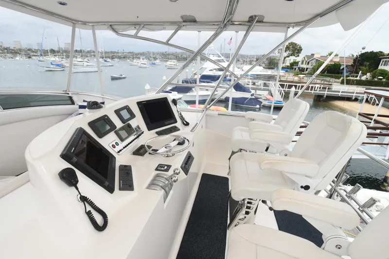Slide: The Image of Helm of 1988 Bertram 54 Convertible yacht with modern navigation equipment and white captain chairs. - 4