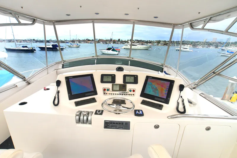 Slide: The Image of Helm of 1988 Bertram 54 Convertible yacht with navigation equipment, overlooking marina. - 6