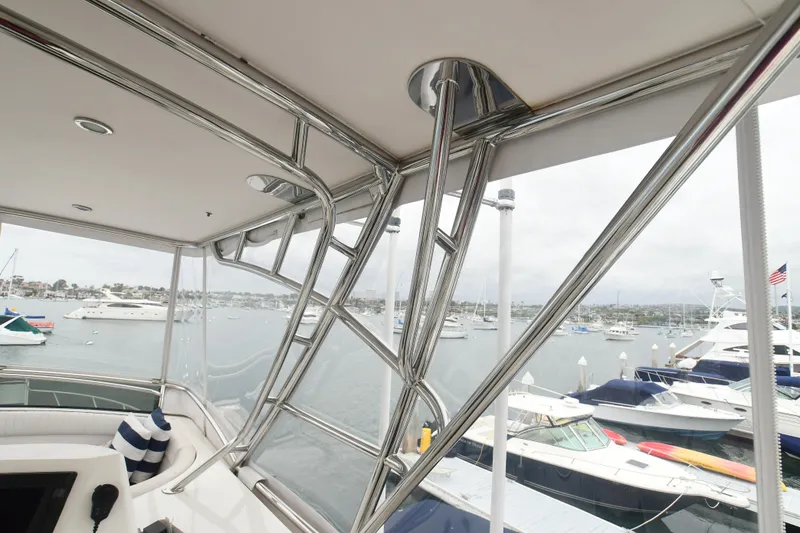 Slide: The Image of 1988 Bertram 54 Convertible yacht interior with marina view, featuring sleek metal framework. - 8