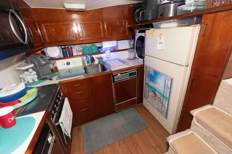 Slide: The Image of 1985 Ocean Yachts 46 Sunliner kitchen with wooden cabinets and modern appliances. - 13