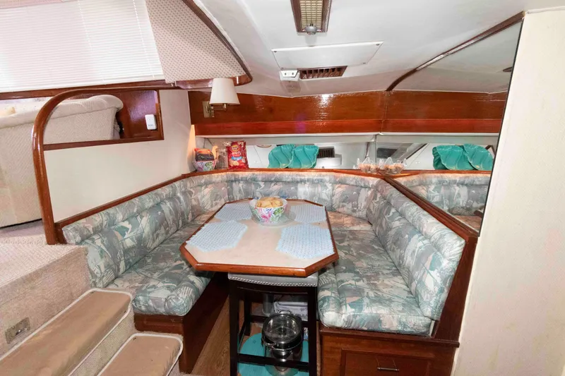 Slide: The Image of 1985 Ocean Yachts 46 Sunliner interior with cozy dining area and patterned seating. - 14