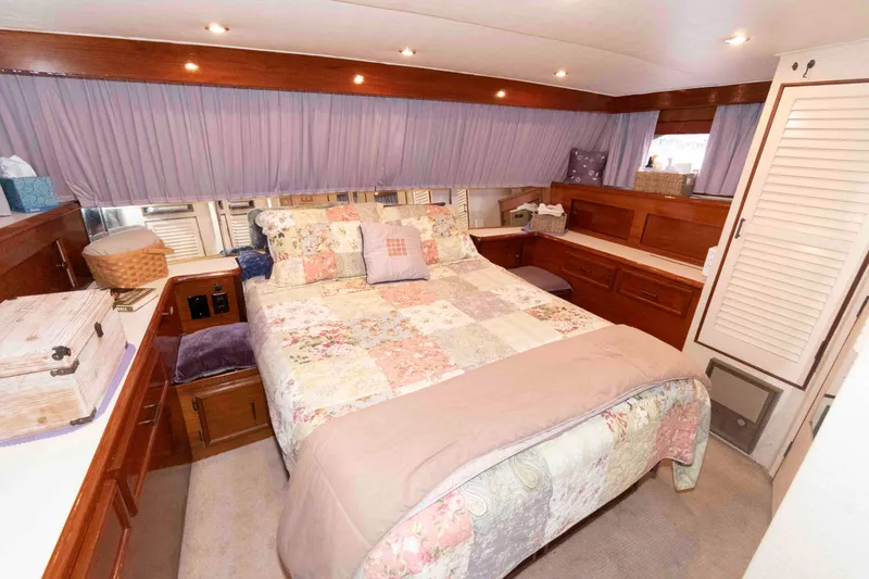 Slide: The Image of Cozy bedroom interior of 1985 Ocean Yachts 46 Sunliner with quilted bedding and wooden cabinetry. - 16