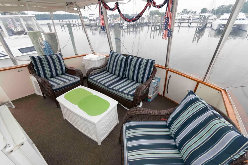 Slide: The Image of 1985 Ocean Yachts 46 Sunliner interior with striped seating, overlooking marina. - 3